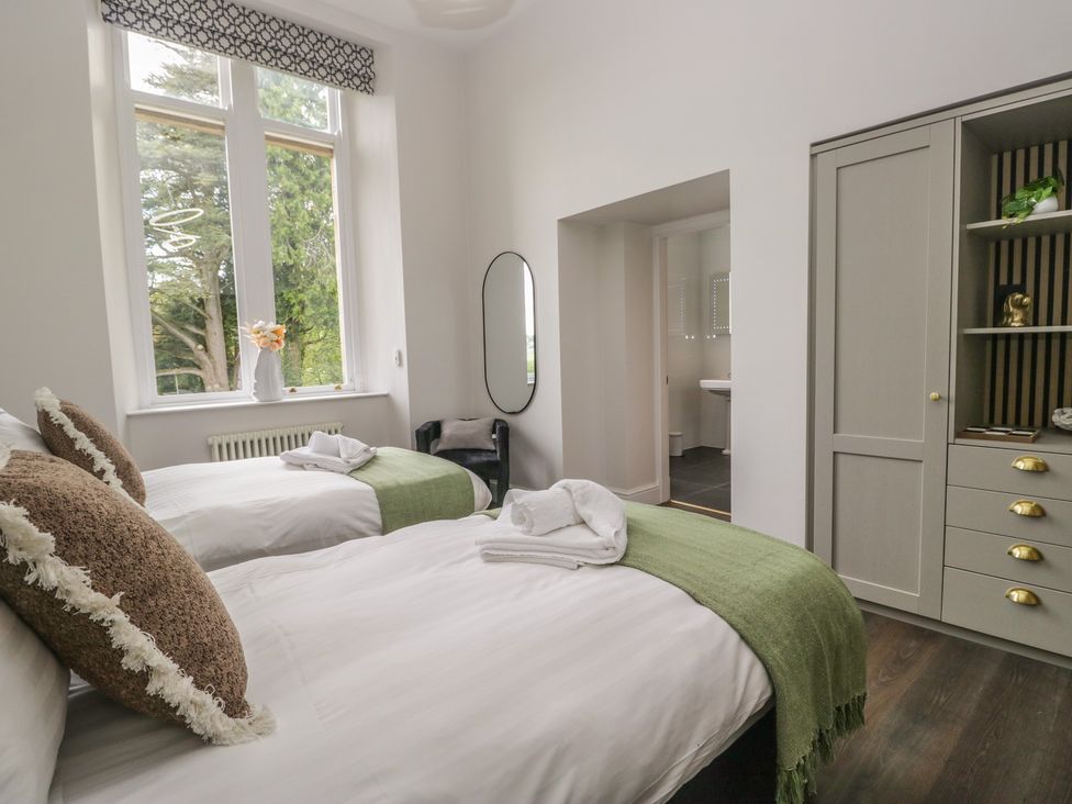A bedroom with two beds and a mirror at Brettargh Holt Mansion near Levens