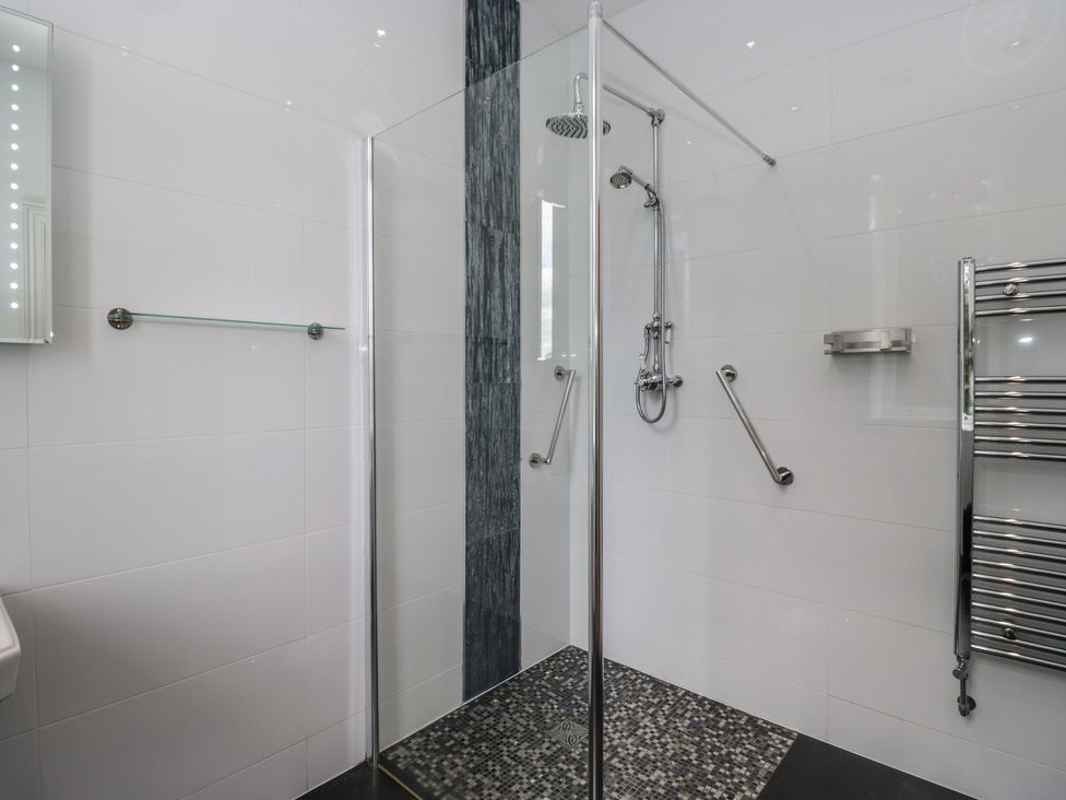A shower with glass door and chrome fittings at Brettargh Holt Mansion near Levens