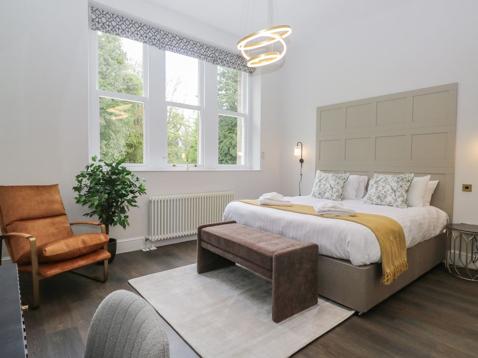 A bedroom with a bed and chairs at Brettargh Holt Mansion near Levens