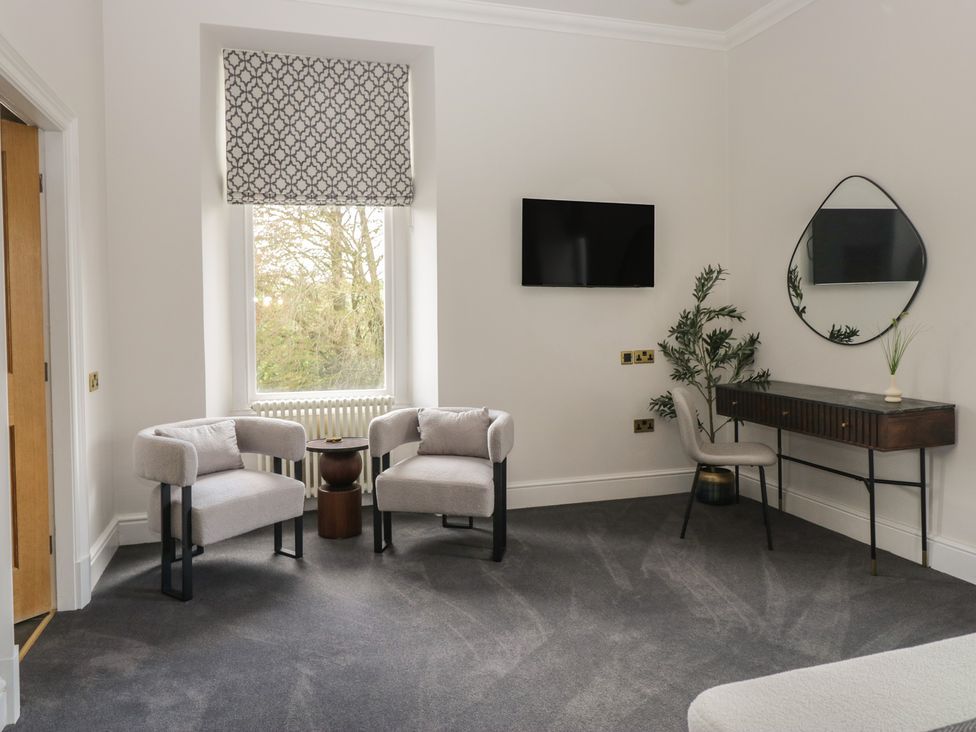 A living room with armchairs and a console table at Brettargh Holt Mansion near Levens