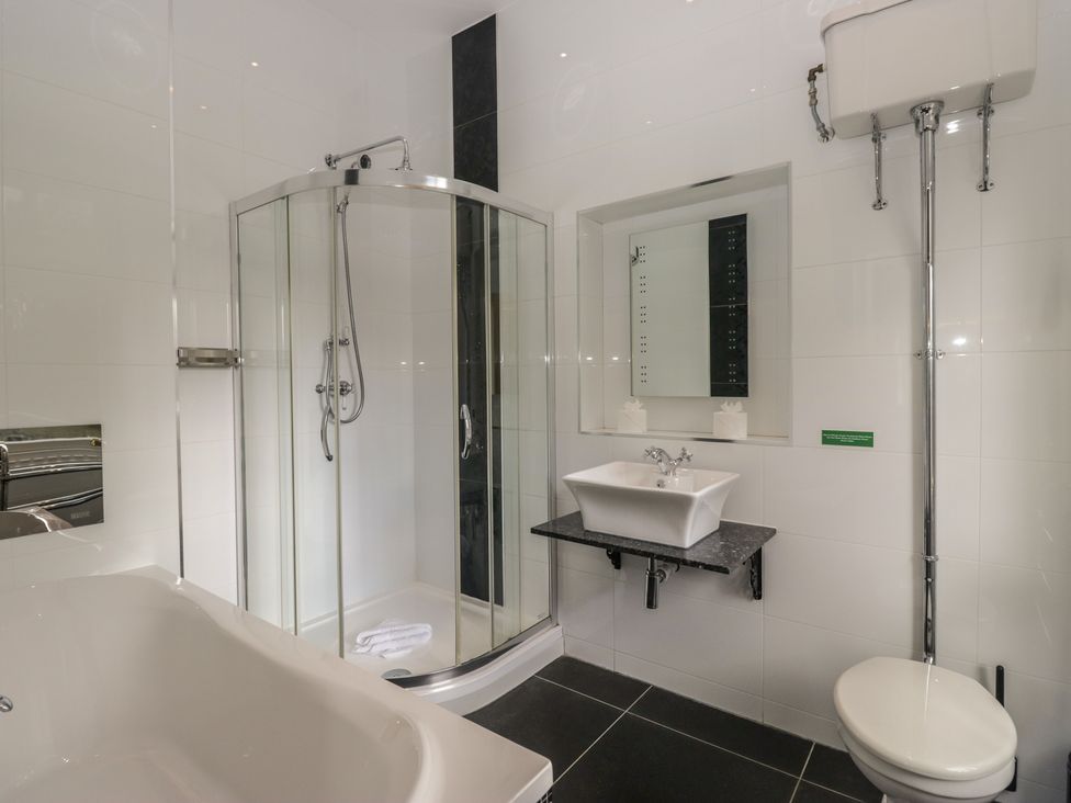 A bathroom with a shower, bathtub, sink, and toilet at Brettargh Holt Mansion near Levens