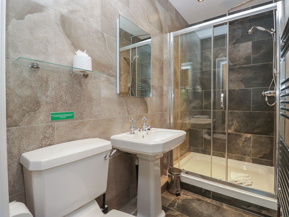 A bathroom with a toilet, sink, and shower at Brettargh Holt Mansion near Levens