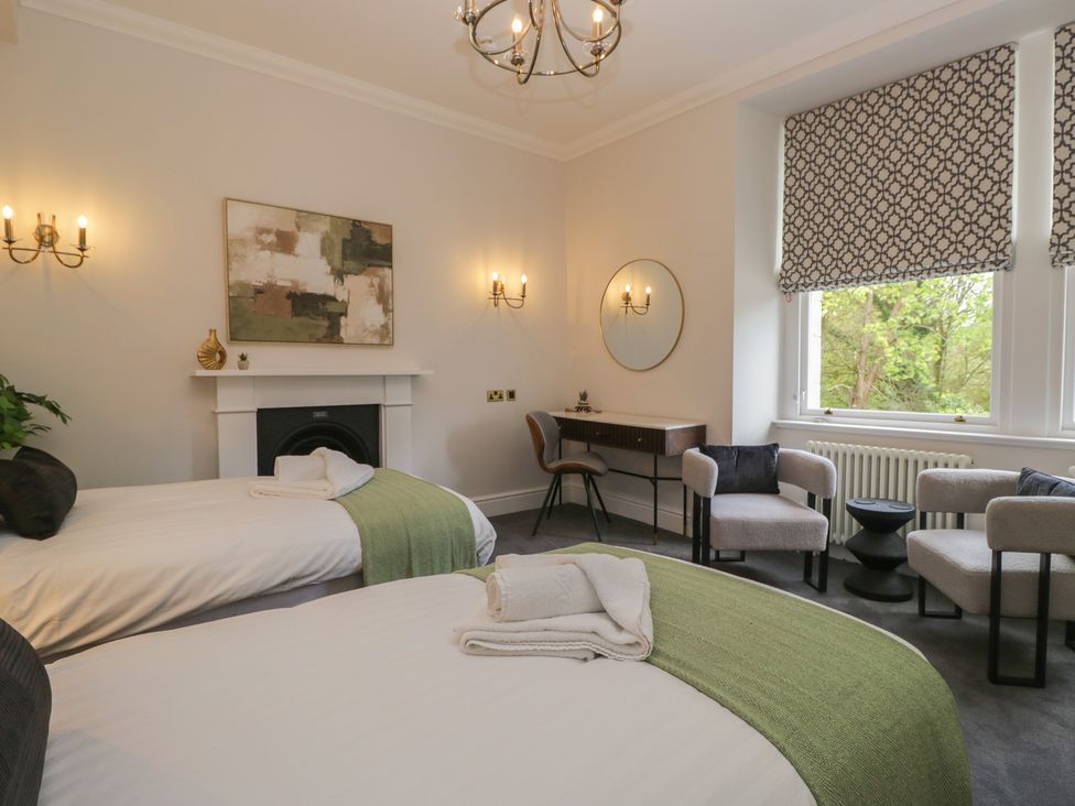 A bedroom with two beds and a writing desk at Brettargh Holt Mansion near Levens