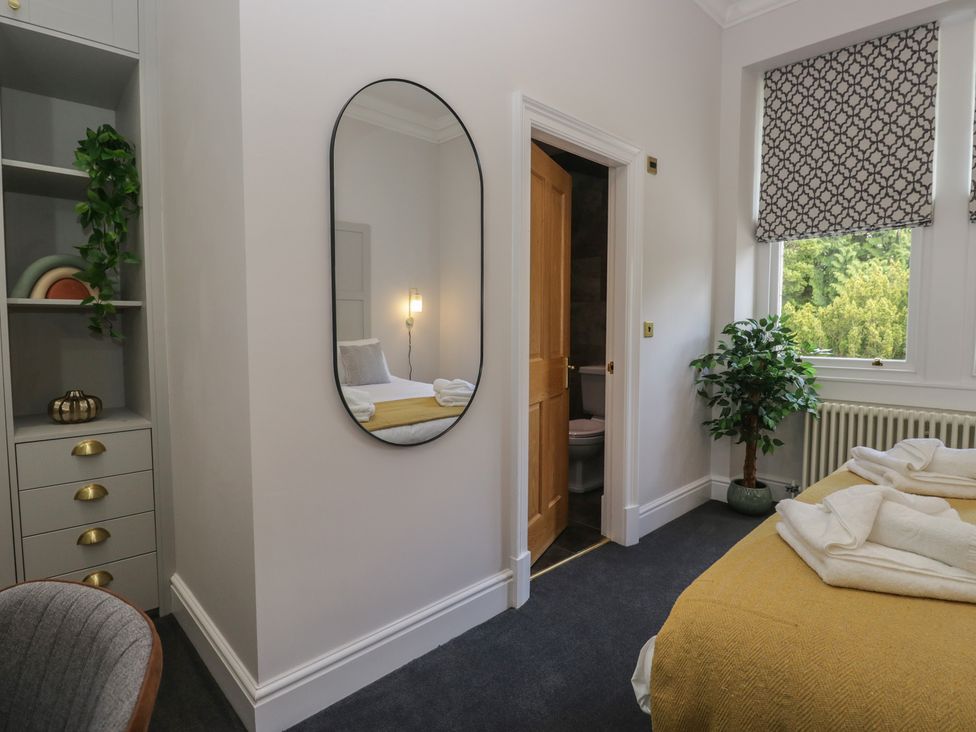 A bedroom with a bed and a mirror at Brettargh Holt Mansion near Levens