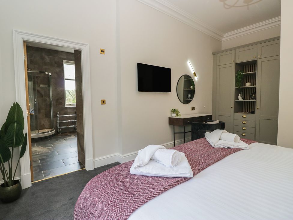 A bedroom with a bed and a shower area at Brettargh Holt Mansion near Levens