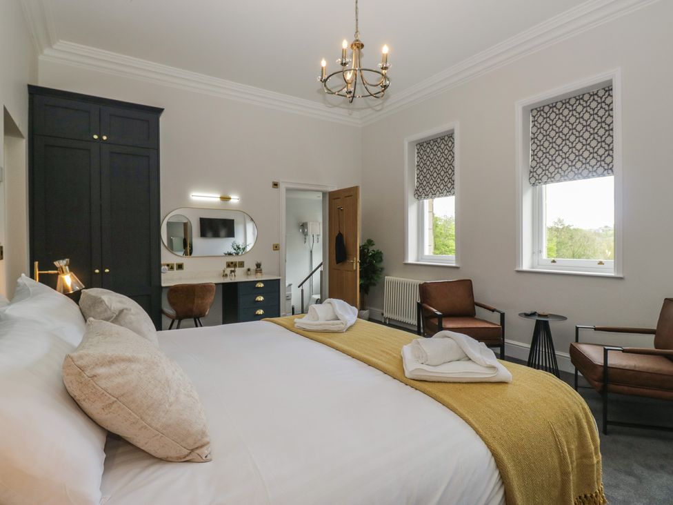 A bedroom with a bed and chairs at Brettargh Holt Mansion near Levens