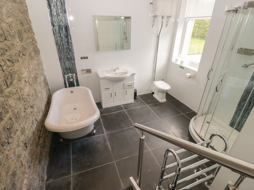 A bathroom featuring a bathtub, sink, shower, and toilet at Brettargh Holt Mansion near Levens