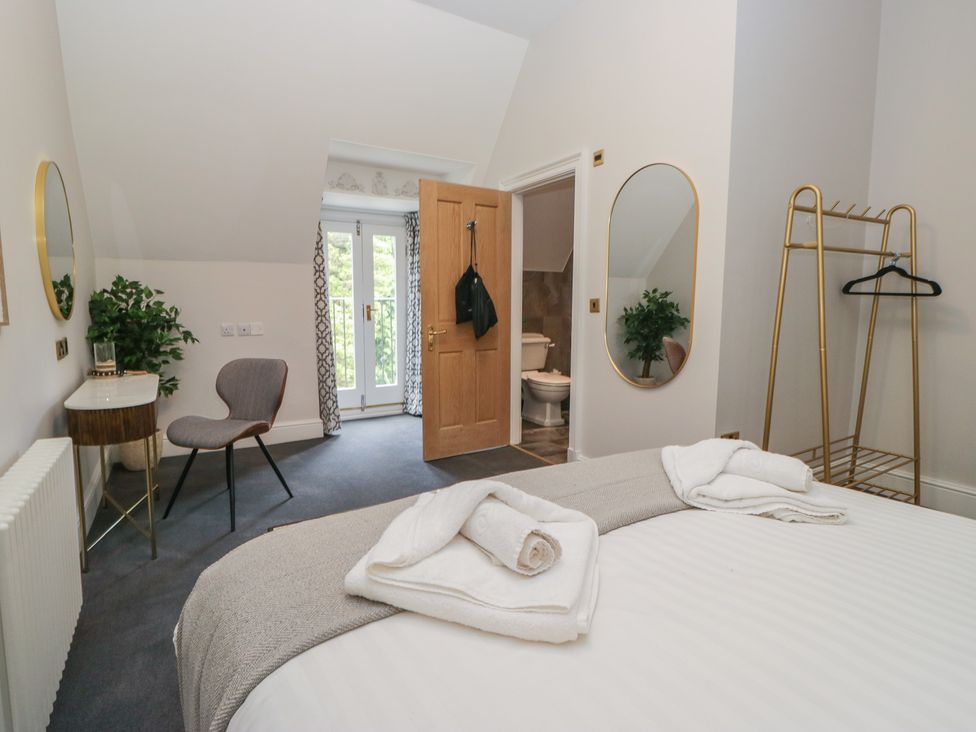 A bedroom with a bed and side table at Brettargh Holt Mansion near Levens