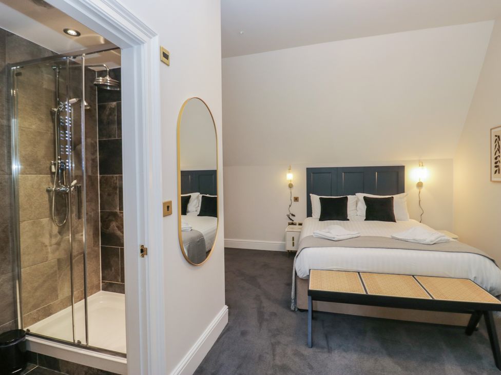 A bedroom with a shower and mirror at Brettargh Holt Mansion near Levens