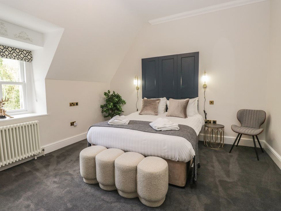 A bedroom with a bed and chair at Brettargh Holt Mansion near Levens