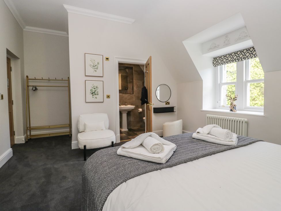 A bedroom with a bed and side chair at Brettargh Holt Mansion near Levens