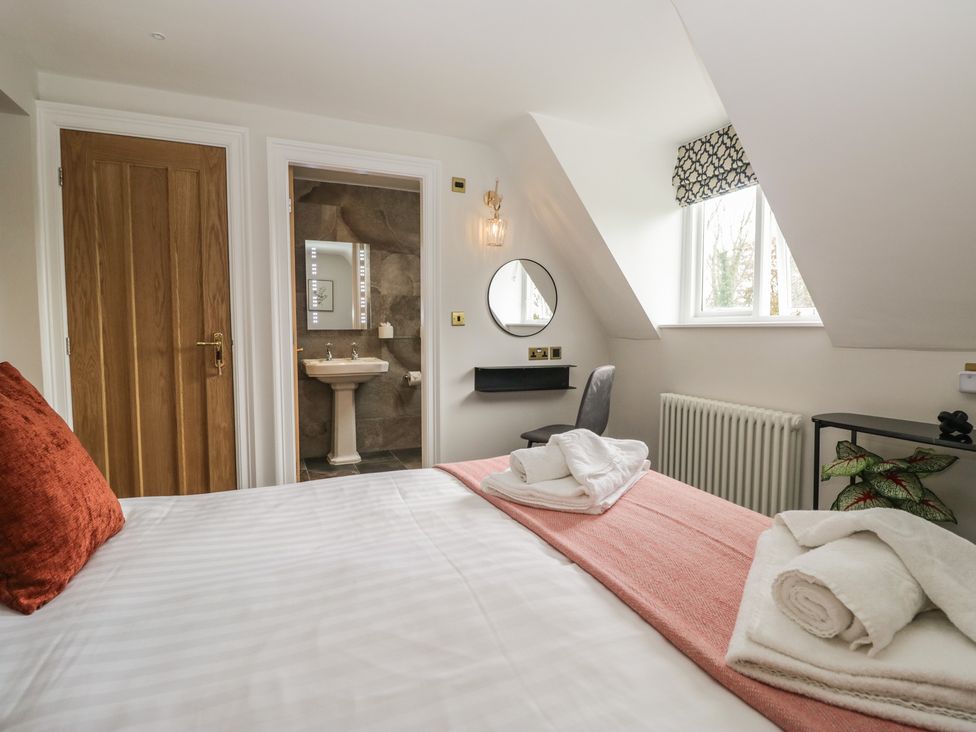 A bedroom with a bed and a sink area at Brettargh Holt Mansion near Levens