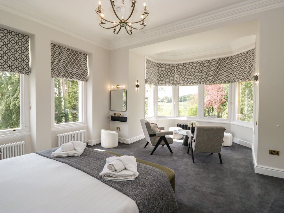 A bedroom with a bed and seating area at Brettargh Holt Mansion near Levens