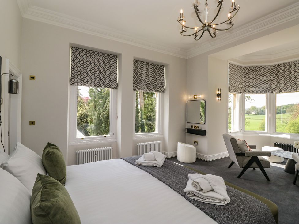 A bedroom with a bed, chair and table at Brettargh Holt Mansion near Levens