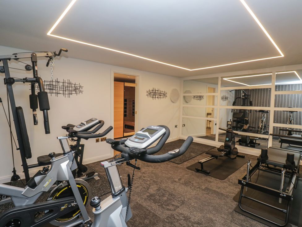 A gym with exercise equipment and mirrors at Brettargh Holt Mansion near Levens