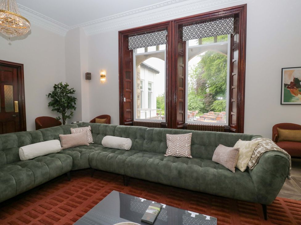 A living room with a green sofa and coffee table at Brettargh Holt Mansion Sleeping 48 near Sizergh, Cumbria
