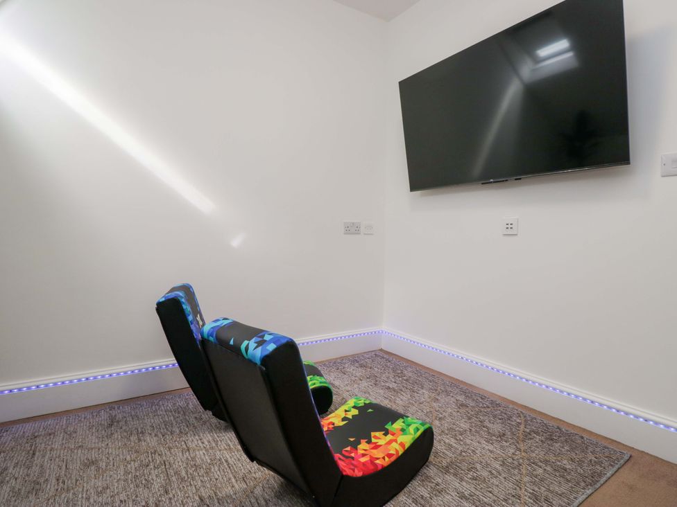 A game room with colorful armchairs and a TV at Brettargh Holt Mansion Sleeping 48 near Sizergh, Cumbria