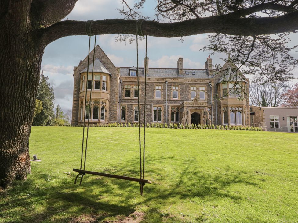 A house with a swing hanging from a tree and a lawn at Brettargh Holt Mansion 32 near Levens