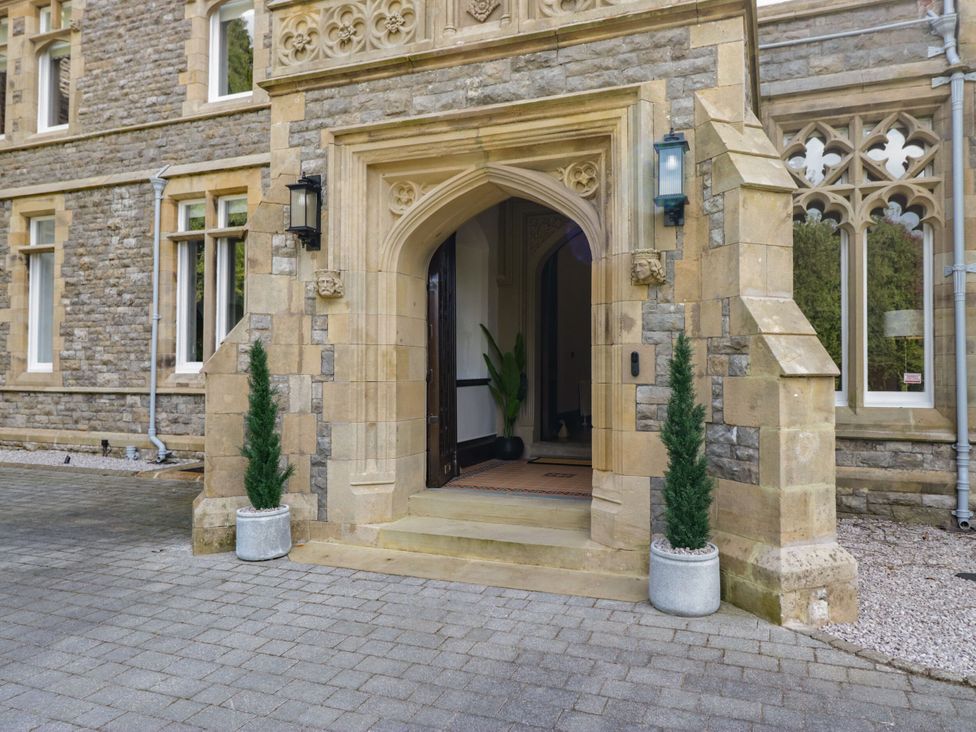 An entrance with a stone door frame and potted plants at Brettargh Holt Mansion 32 near Levens