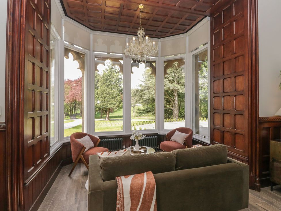 A living room with a chandelier and seating area at Brettargh Holt Mansion 32 near Levens