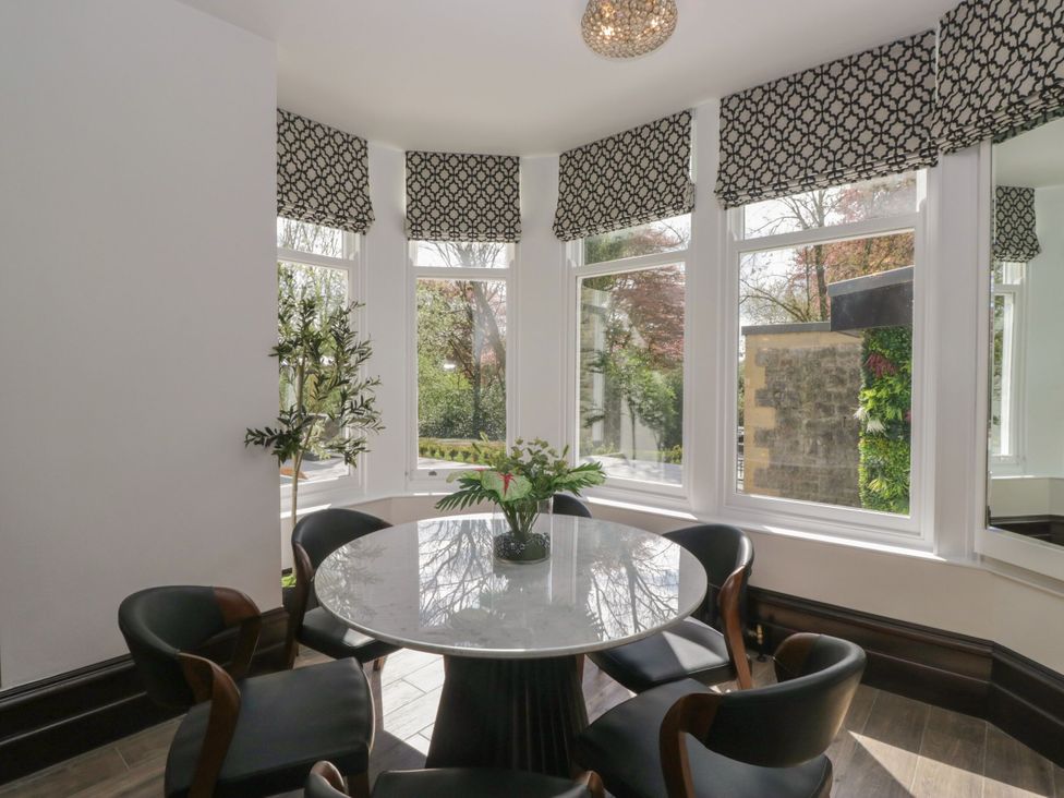 A dining room with a round table and chairs at Brettargh Holt Mansion 32 near Levens