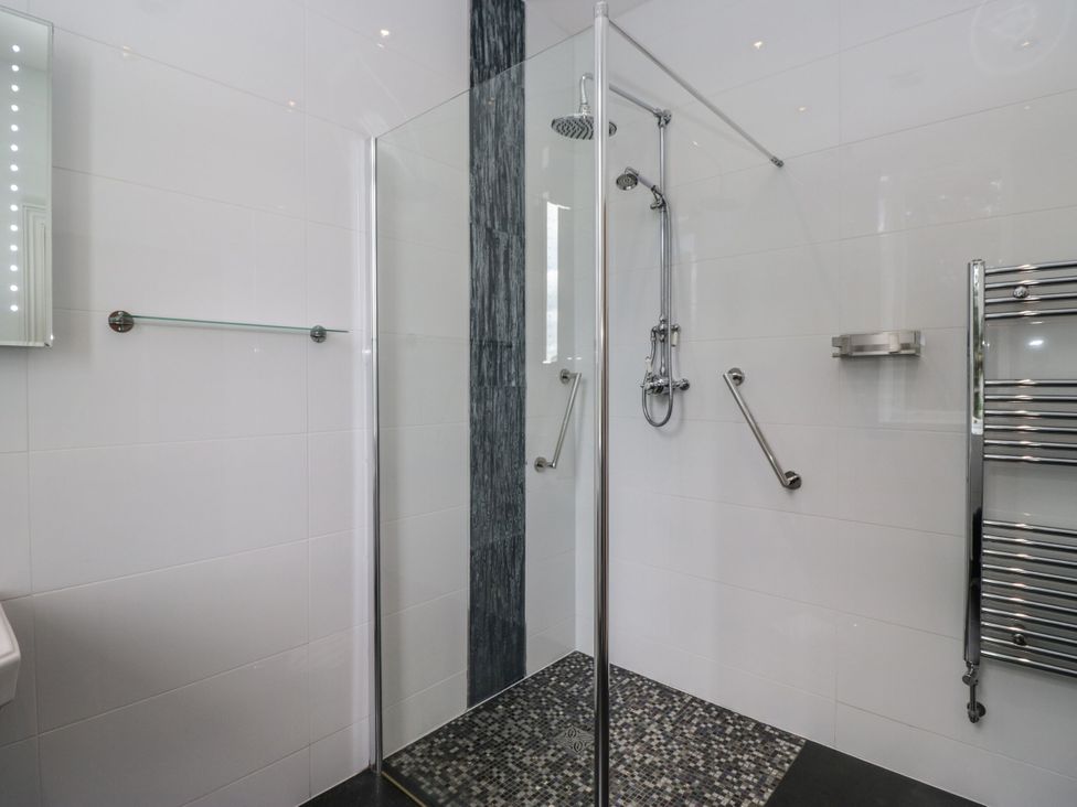 A bathroom with a shower and towel rail at Brettargh Holt Mansion 32 near Levens