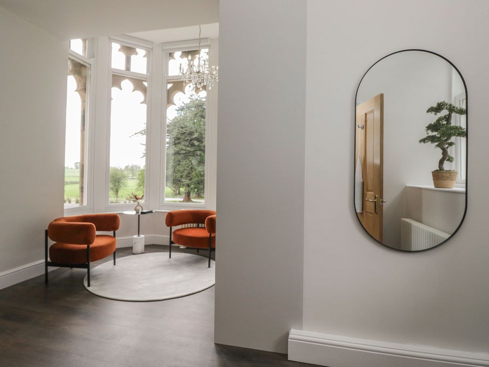 A space with orange chairs and a mirror at Brettargh Holt Mansion 32 near Levens