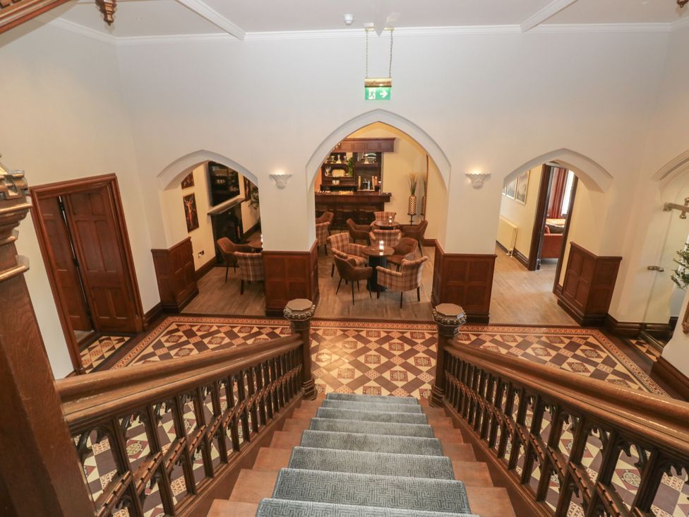 An entrance hall with a staircase leading to a bar area at Brettargh Holt Mansion 32 near Levens