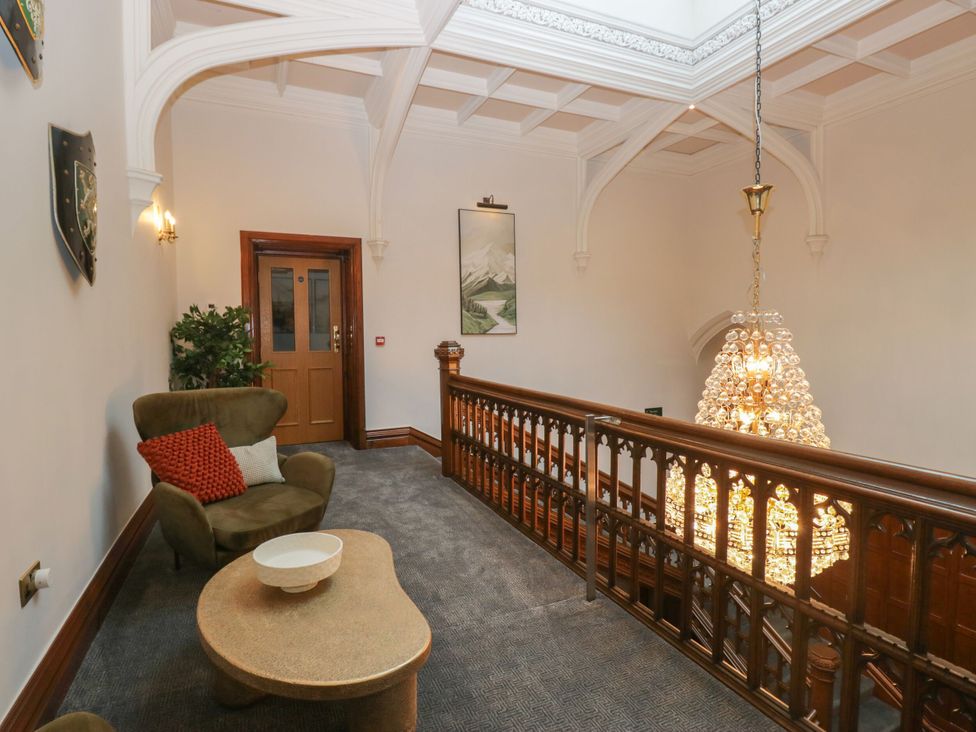 A hallway with a sofa and chandelier at Brettargh Holt Mansion 32 near Levens