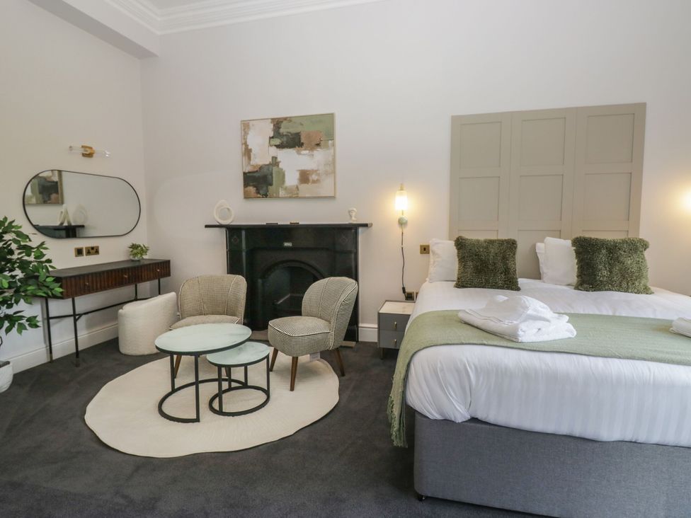 A bedroom with a bed, seating area and fireplace at Brettargh Holt Mansion 32 near Levens