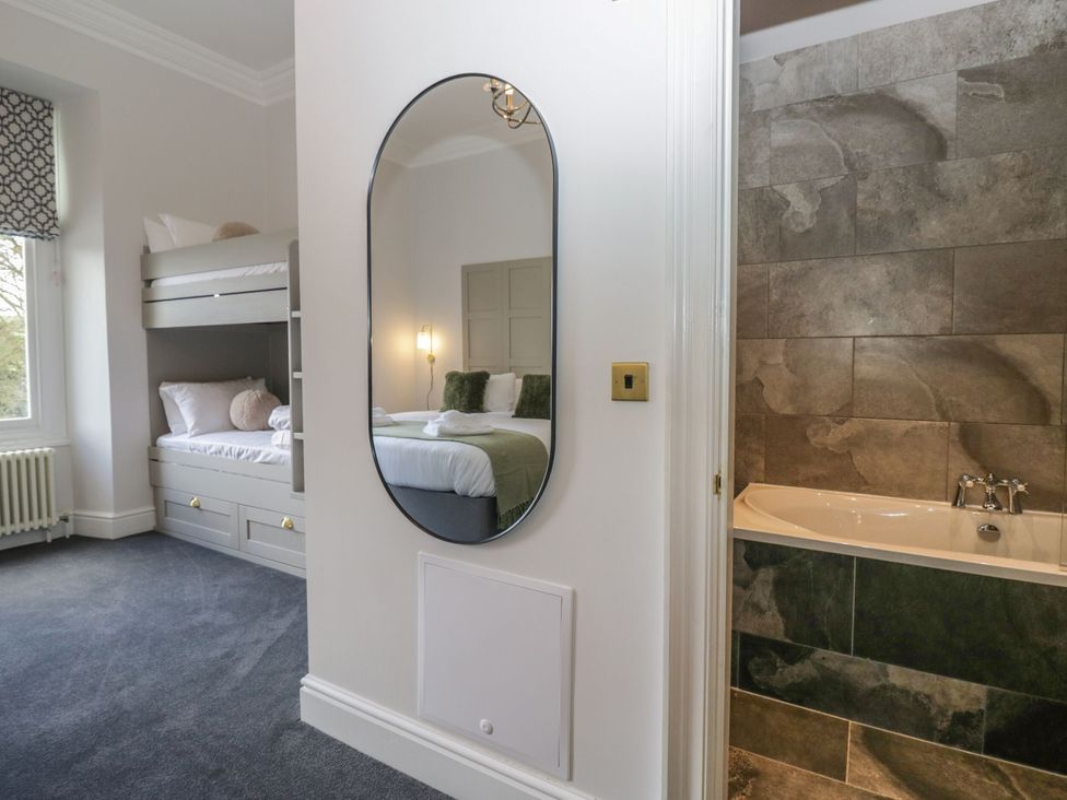 A bedroom with a bunk bed and a bathtub at Brettargh Holt Mansion 32 near Levens