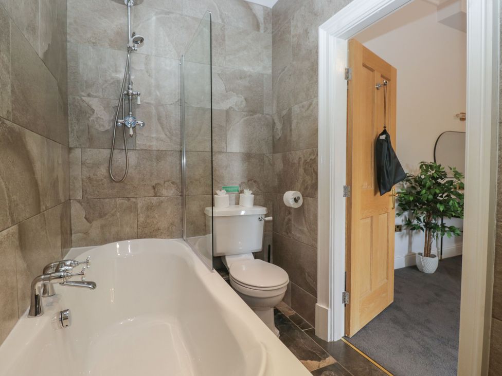 A bathroom featuring a bathtub and toilet at Brettargh Holt Mansion 32 near Levens