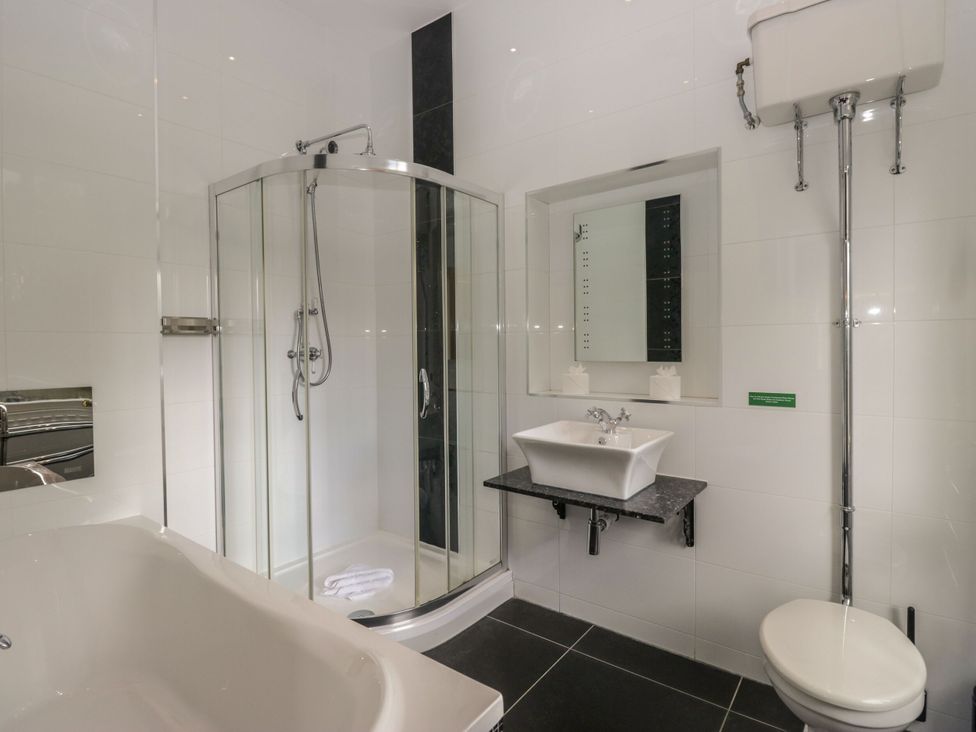 A bathroom with a bathtub, shower, sink, and toilet at Brettargh Holt Mansion 32 near Levens