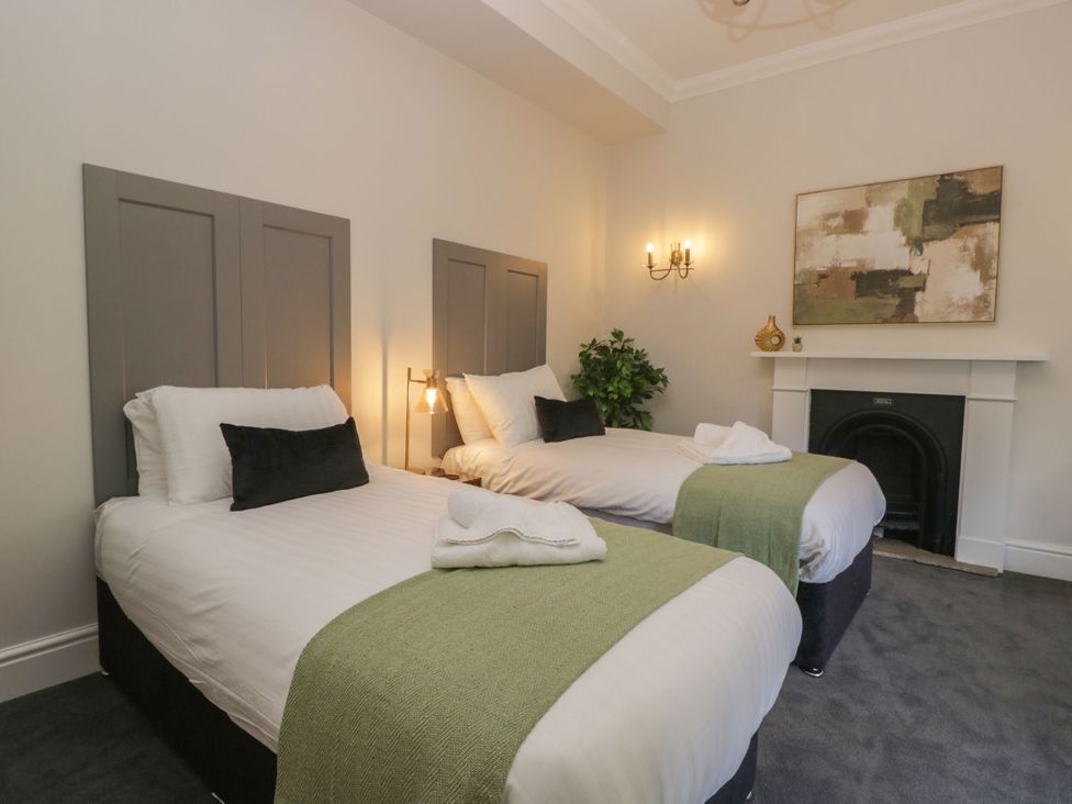 A bedroom with two beds and a fireplace at Brettargh Holt Mansion 32 near Levens