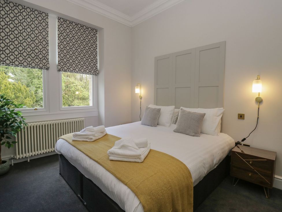 A bedroom with a bed, bedside table and windows at Brettargh Holt Mansion 32 near Levens