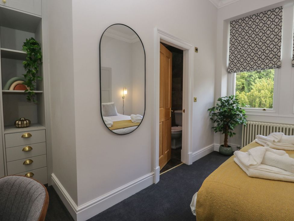 A bedroom with a bed and a wall mirror at Brettargh Holt Mansion 32 near Levens