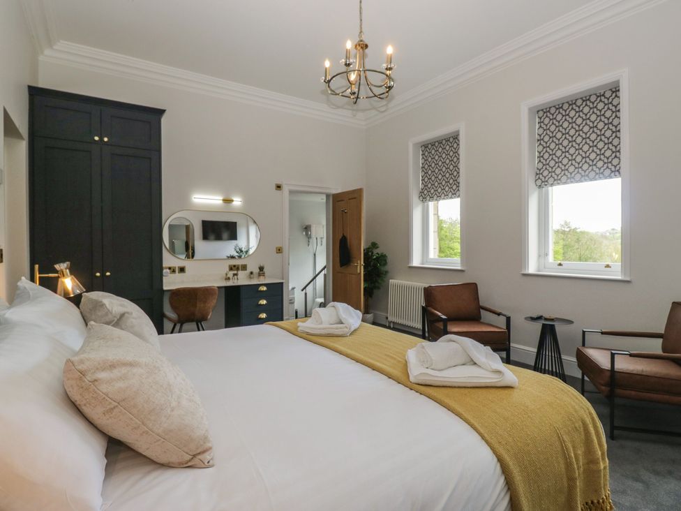 A bedroom with a bed and chairs at Brettargh Holt Mansion 32 near Levens