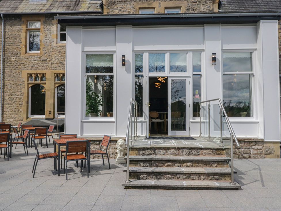 An outdoor seating area with tables and chairs at Brettargh Holt Mansion 32 near Levens