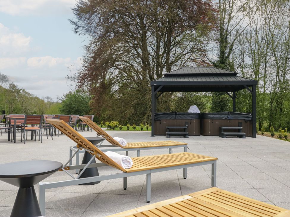 An outdoor area with lounge chairs and hot tubs at Brettargh Holt Mansion 32 near Levens
