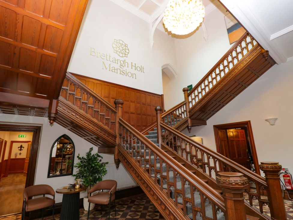 An entrance hall with a staircase and chandelier at Brettargh Holt Mansion near Sizergh, Cumbria