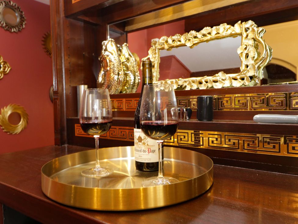 A bar area with wine glasses and a bottle at Brettargh Holt Mansion Sleeping 32 near Sizergh, Cumbria