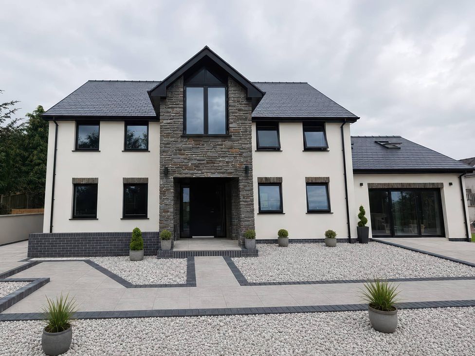 A modern house with stone features and landscaped front at Brynseion Uchaf in Aberystwyth