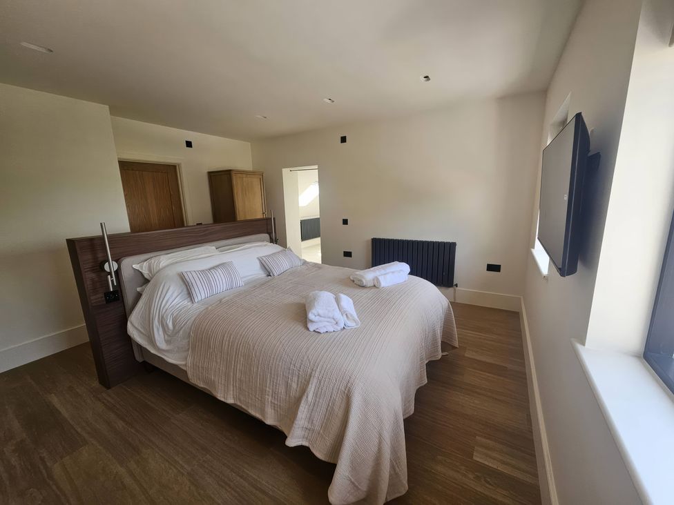 A bedroom with a bed and television at Brynseion Uchaf in Aberystwyth