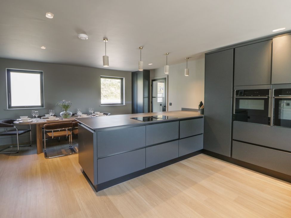 A kitchen featuring an island, cabinets, and dining area at Brynseion Uchaf near Aberystwyth