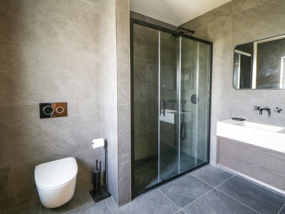 A bathroom with a shower, toilet, and sink at Brynseion Uchaf near Aberystwyth