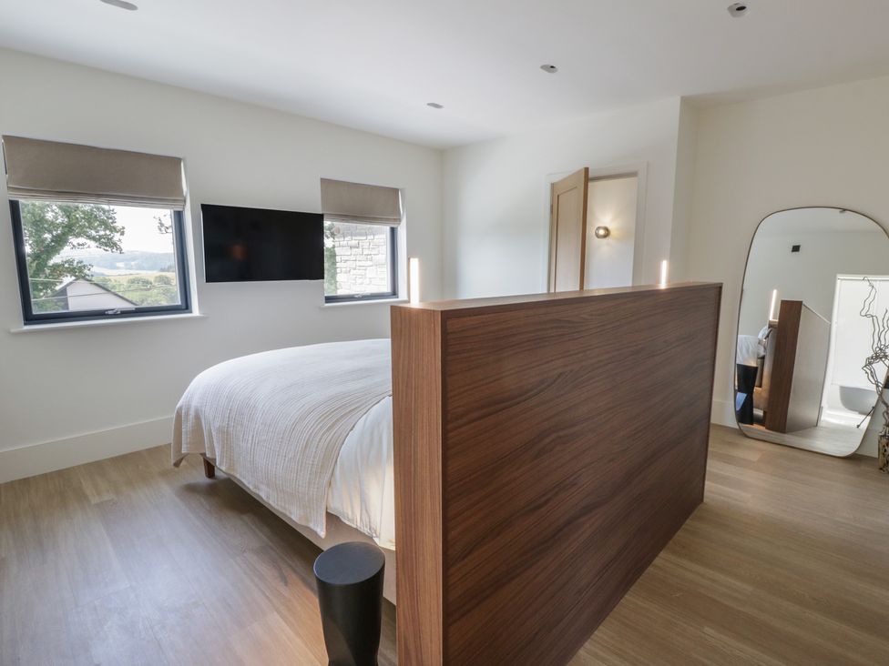 A bedroom with a bed and wooden divider at Brynseion Uchaf near Aberystwyth