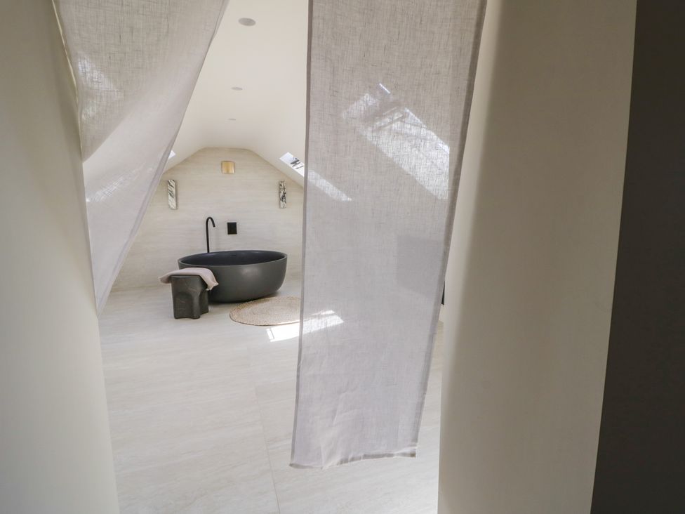 A bathroom with a bath tub and wall sconces at Brynseion Uchaf near Aberystwyth