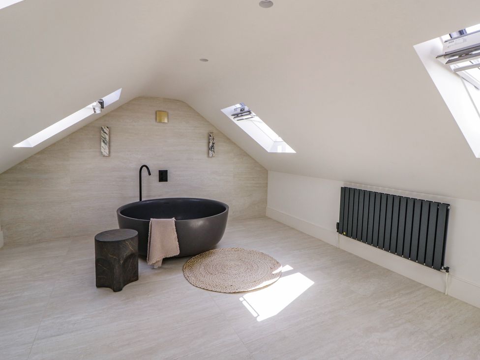 A bathroom with a bathtub and stool at Brynseion Uchaf near Aberystwyth