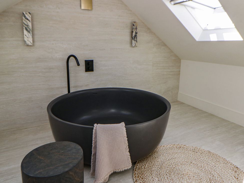 A bathroom with a black bathtub and a towel at Brynseion Uchaf near Aberystwyth