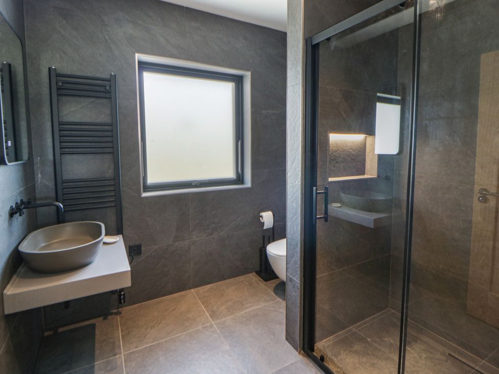 A bathroom with a sink, toilet, and shower at Brynseion Uchaf near Aberystwyth